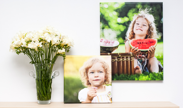 2 spring photo canvases of a small girl next to a flower bucket2 fotolienzos de primavera que muestran una pequeña niña, una rama de flores al lados de las fotos.