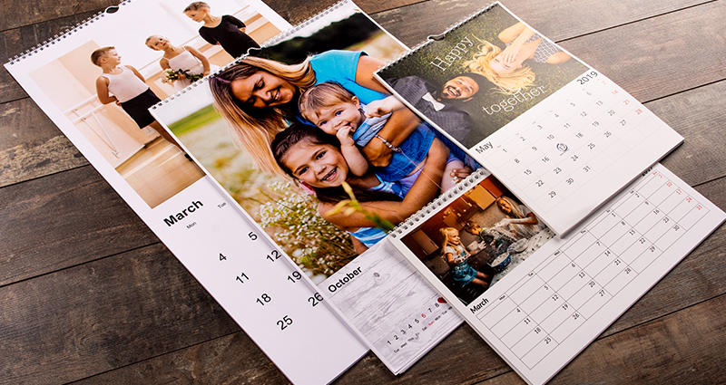4 calendriers photo deColorland – 4 formats différents étalés sur un plancher en bois.