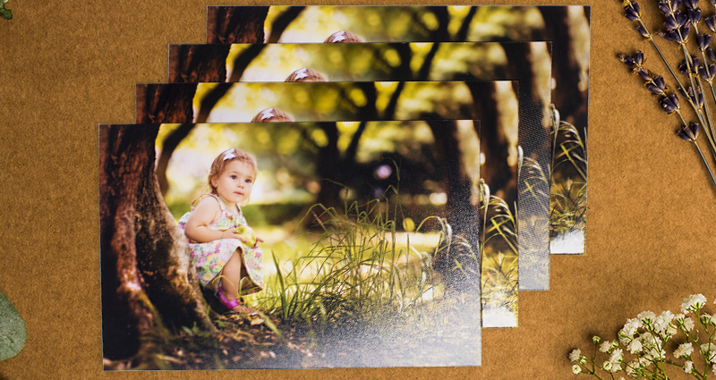 Vier foto's van een klein meisje dat onder een boom zich bevindt. Foto's afgedrukt op vier verschillende soorten papier.