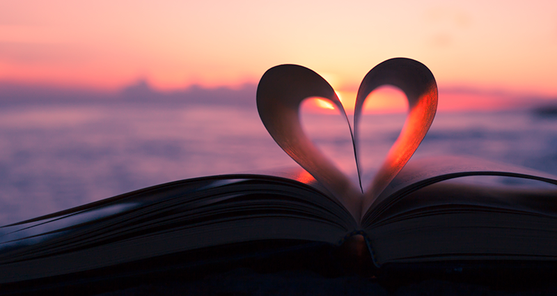 Un libro con un corazón y puesta del sol