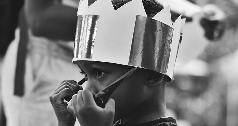 A boy wearing a crown.