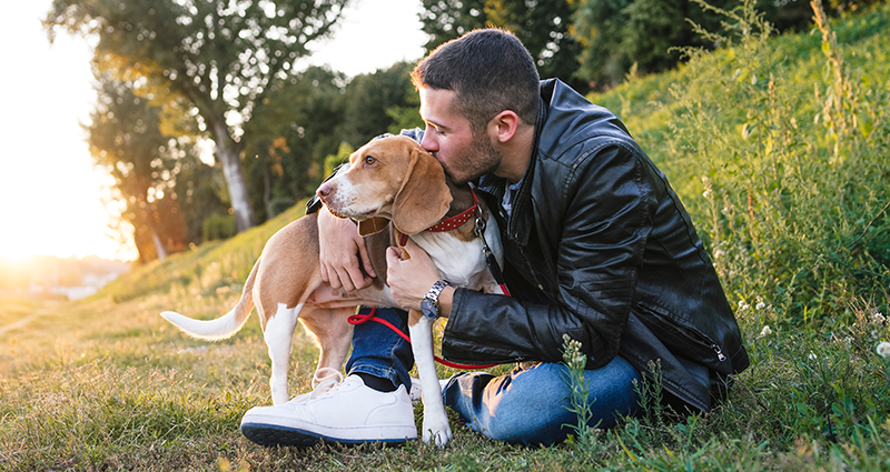 Un uomo con il suo cane in posa per una foto che verrà utilizzata in seguito in un album fotografico personalizzato per cani