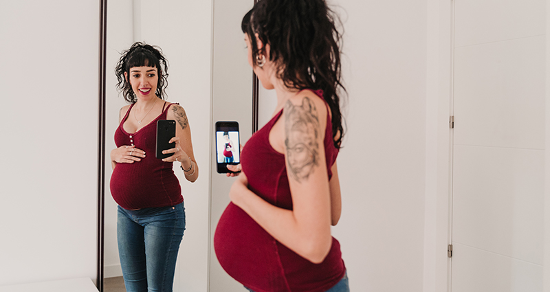 Těhotná žena v zrcadle pořizující selfíčko