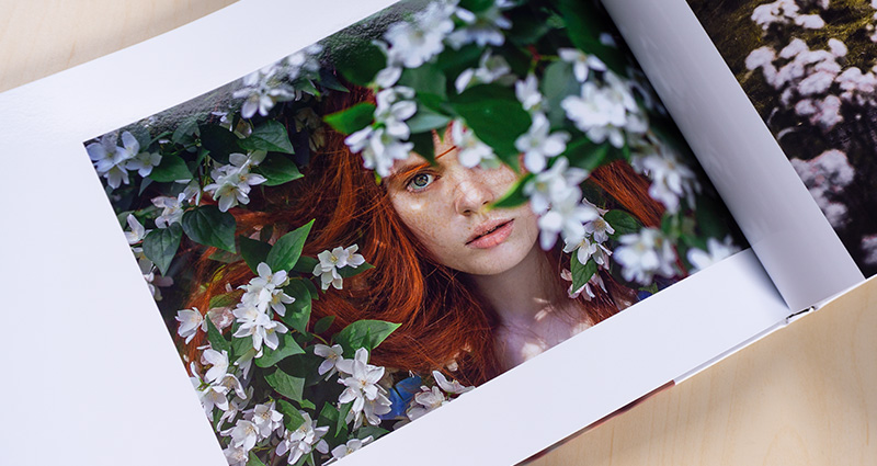 Close-up on a photo from the Starbook with a red-headed woman. White blooming trees in the background.