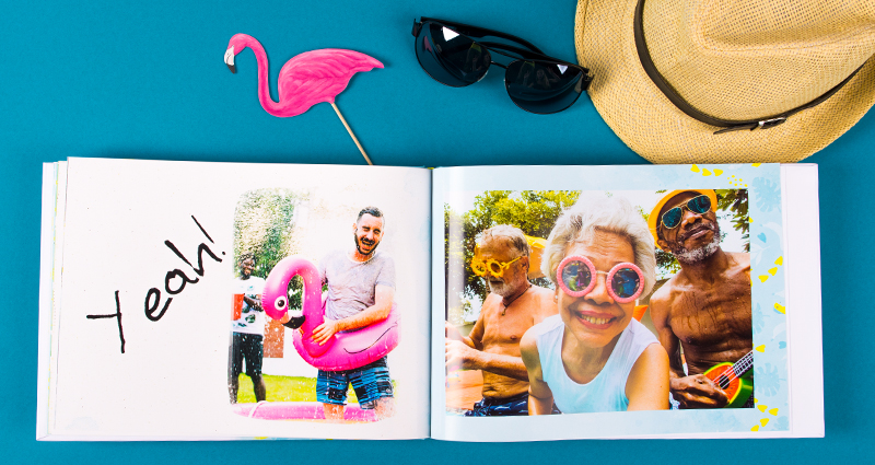 Family holiday photobook with a clipart, a straw hat, sunglasses and a pink flamingo above.  Un livre photo de famille avec des photos de vacances, un chapeau de paille, des lunettes et un flamant rose au-dessus.