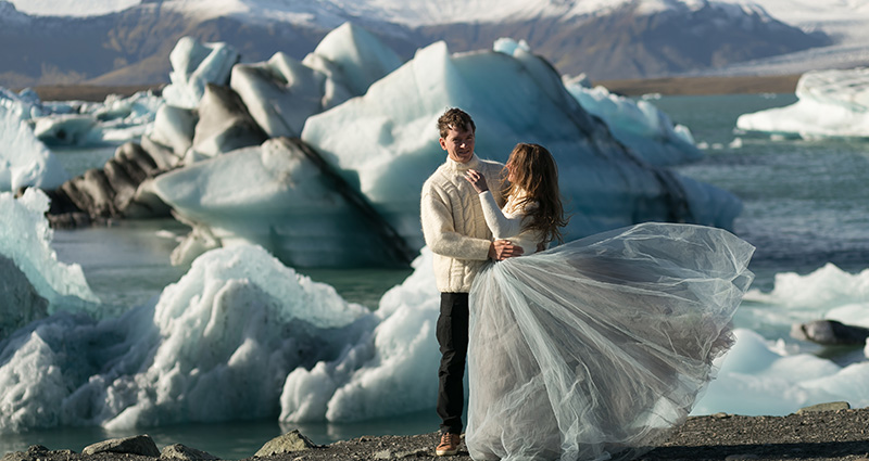 Fotografie mladého páru na Islande, ľadovce v pozadí.