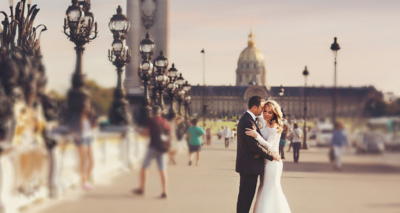 A photo of a newlywed couple holding each other on one of the squares in Paris.