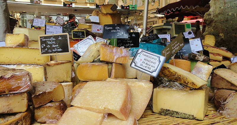 Cucina francese - Una serie di formaggi in blocchi sulla bancarella del mercato.