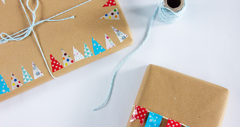 Les cadeaux emballés dans un papier unicolore décoré avec des petits sapins découpés manuellement.