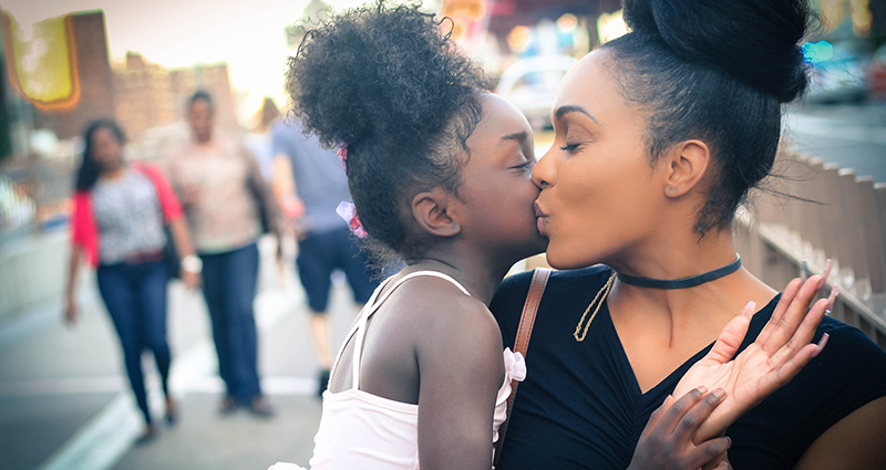 Moeder geeft haar dochter een kus