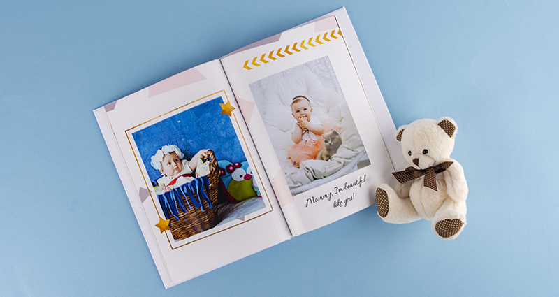 Fotobuch mit Bildern vom Baby-Fotoshooting, daneben ein Kuschelbär - 2.