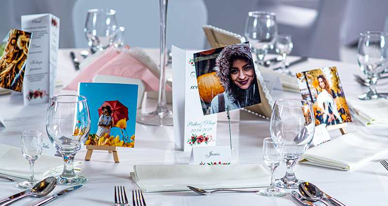 Plaatskaartjes in de vorm van Insta foto’s met foto's van bruiloftsgasten geplaatst op schildersezels.