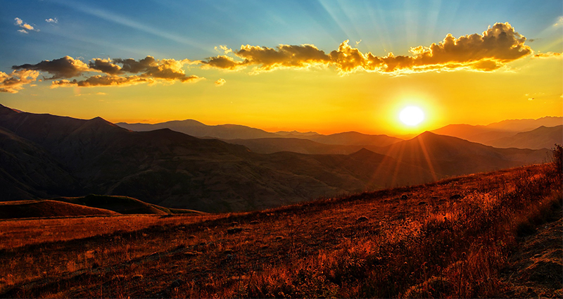 Le coucher du soleil dans la montagne, la photo en couleurs bleu, orange, jaune. 