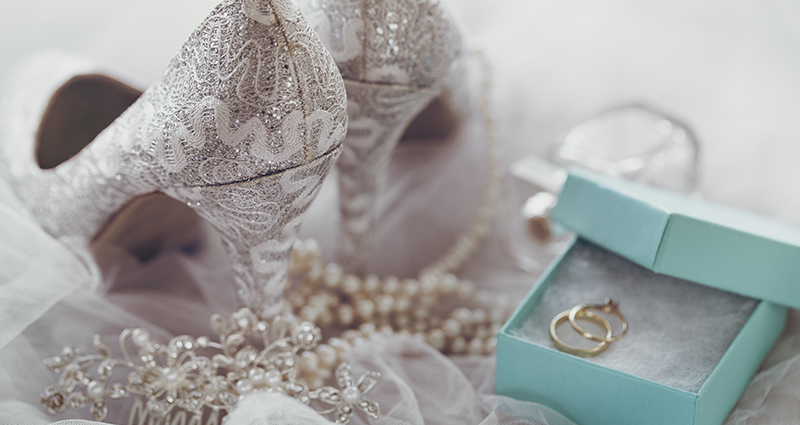 Wedding accessories: shoes, hair decoration, a square decorative box with a wedding ring and an engagement ring inside