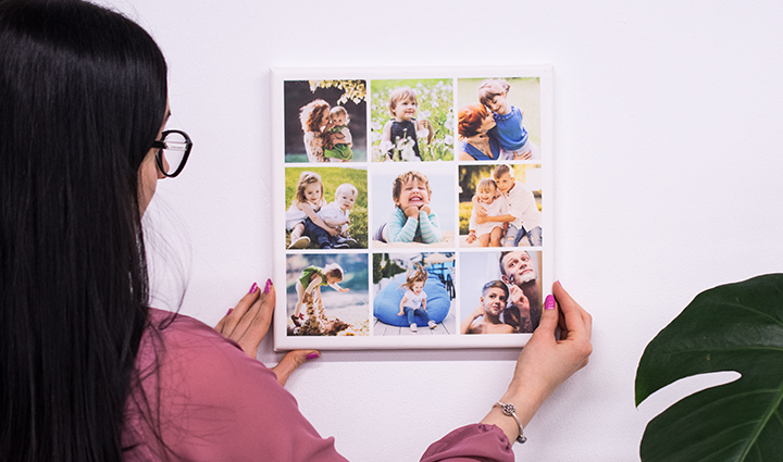 Mujer colgando un lienzo cuadrado en forma de un collage.
