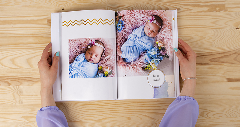 Frau hält in der Hand ein Fotobuch mit Bildern vom Baby-Fotoshooting – 2.