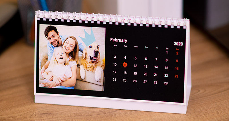 A personalised desk calendar with a black background and clipart
