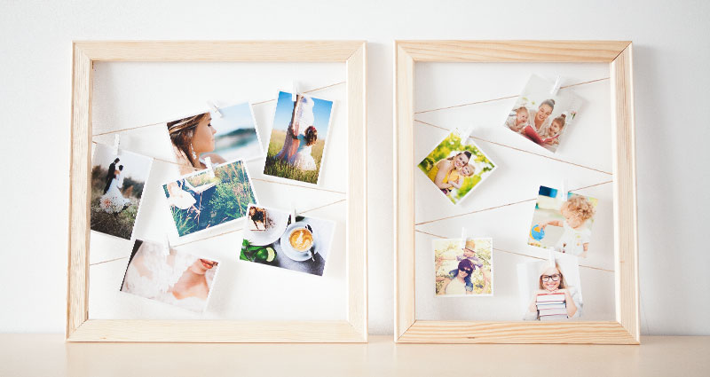 Photos on strings in wooden frames.