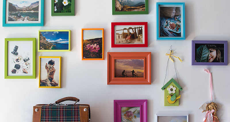 Photos en cadres colorés accrochés sur le mur en couleur.