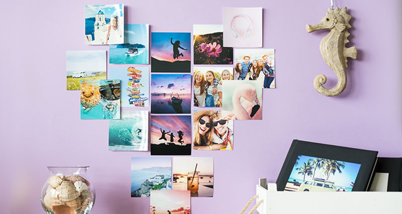 Insta photos in heart-shape on a purple wall.