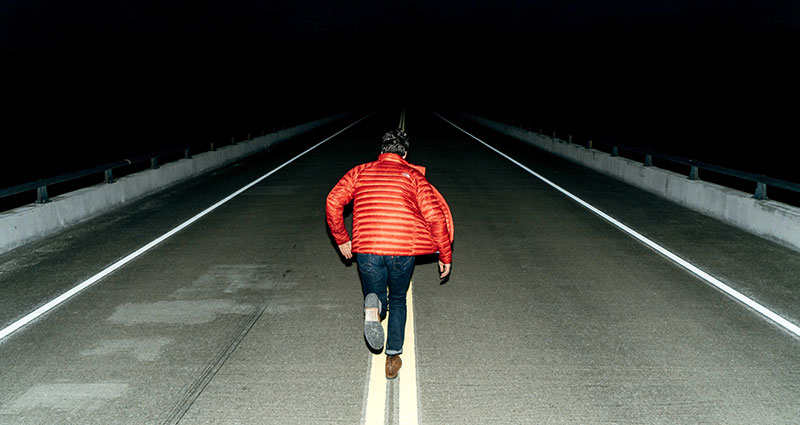 A flash photo of a running man at night.