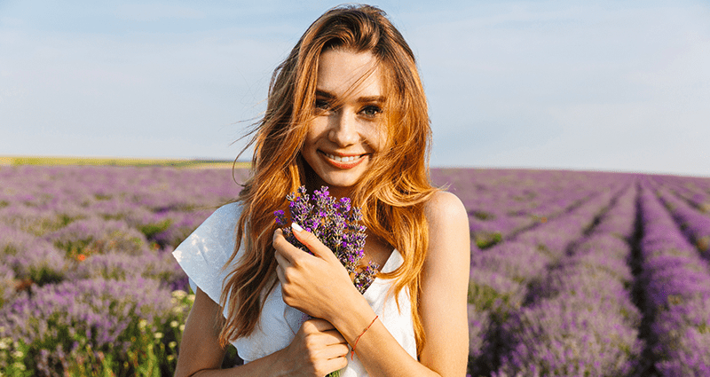 Vrouw die tijdens een outdoor fotoshoot lavendel vasthoudt