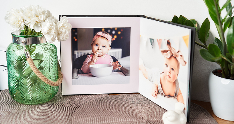 L’album deluxe avec des photos d'un bébé – un souvenir de la première année de vie entourée de fleurs délicates.