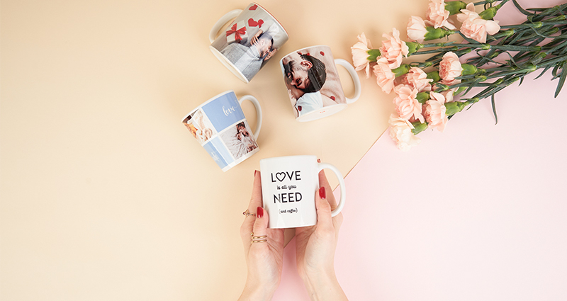 Une femme tient un mug personnalisé avec une photo.