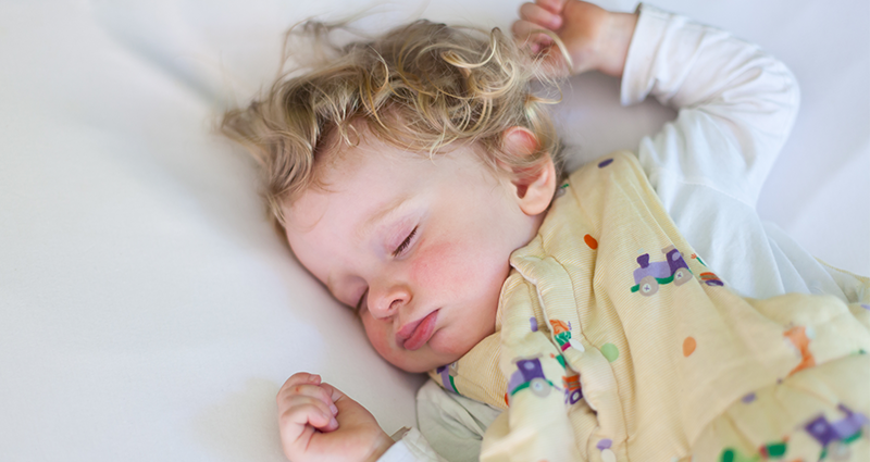 A baby sleeping in a swaddler