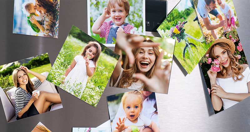 A close-up on photo magnets with spring pictures, child’s drawing and a to-do-list on a fridge.