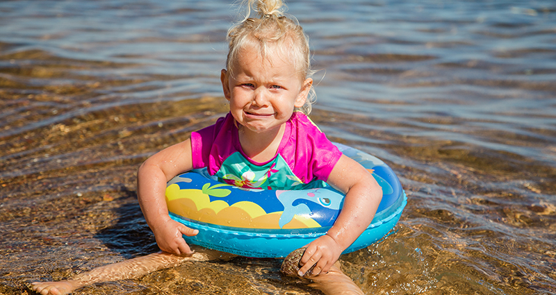 Una bambina che piange sulla spiaggia.