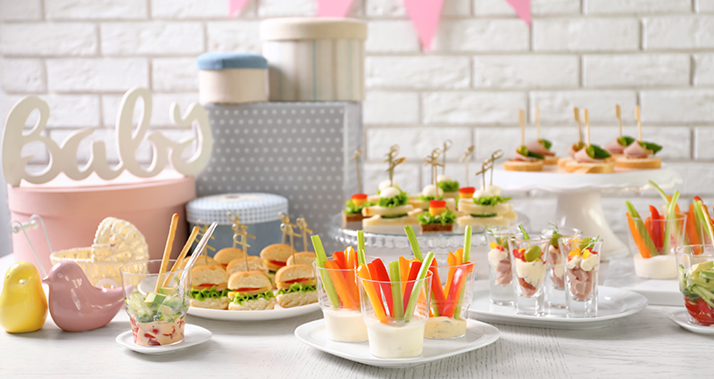 A decorated table with baby shower snacks