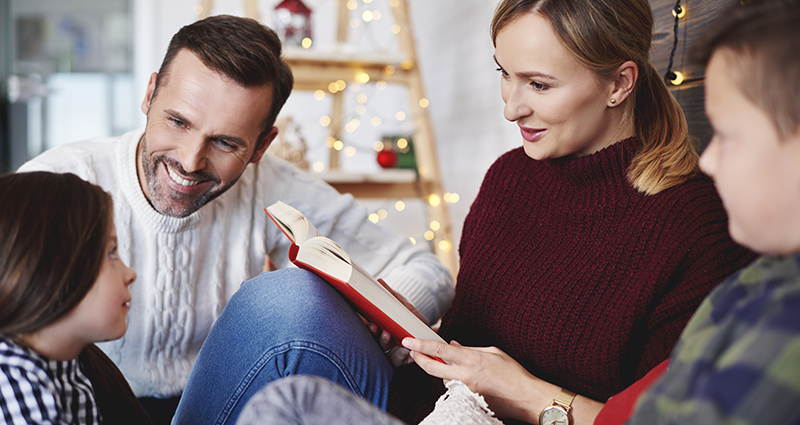 Het lezen van een boek met de familie op kerstmiddag