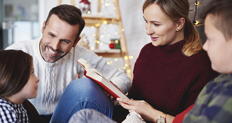 A family reading a book on Christmas evening