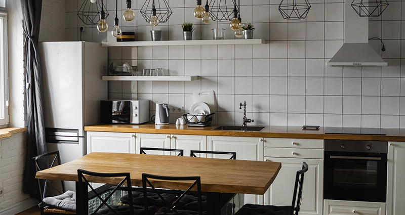 A kitchen with square tiles, and geometric lamps