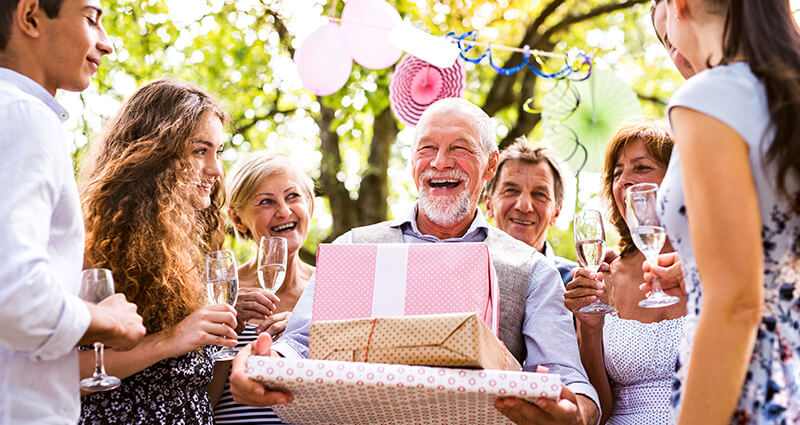 A man is holding a gift with birthday quotes for him