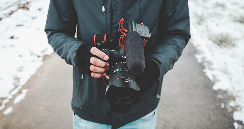 Un homme tenant dans les mains l’appareil photo