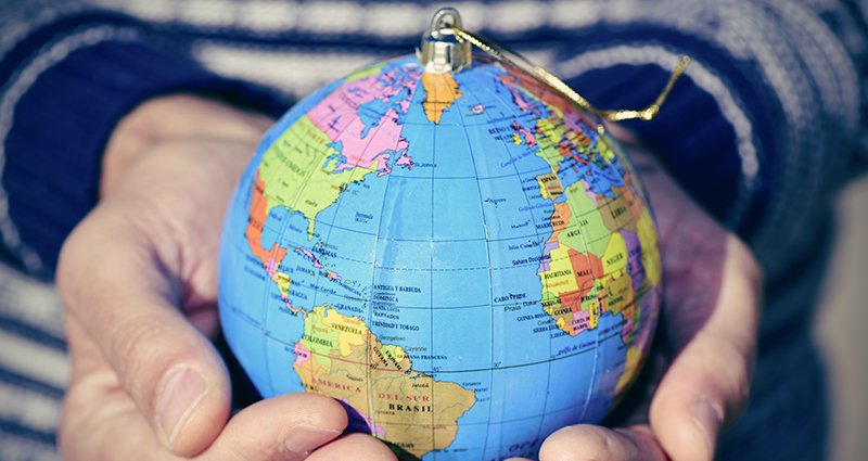 A person holding a small globe