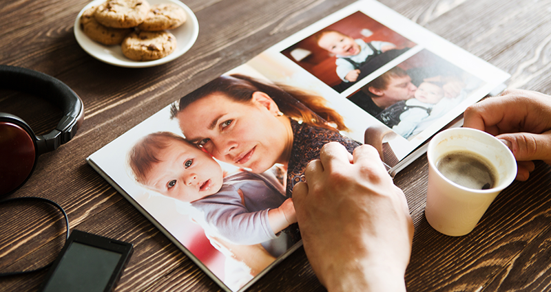 Una persona está viendo un Yearbook con la foto de una madre e hijo y con las frases para el anuario