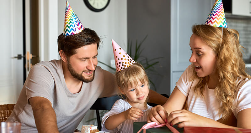 Una donna che tiene in mano un regalo con delle frasi di compleanno per lei