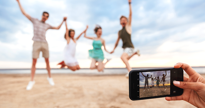 A woman takes a picture of her family using travel photography tips