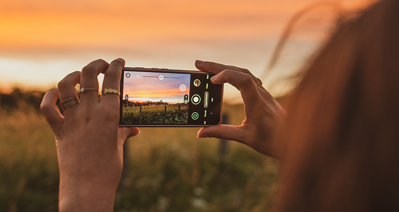 Moteris, kurianti kraštovaizdžio fotografiją, naudodama kraštovaizdžio fotografijos patarimus ir metodus