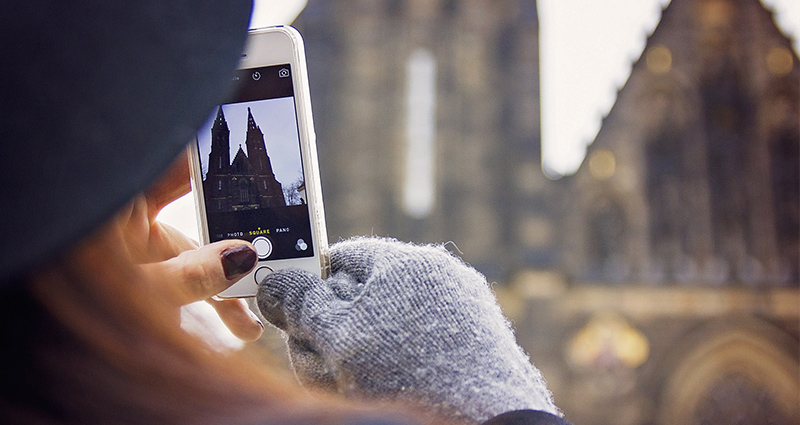 Eine Frau mit Hut macht Fotos im Winter