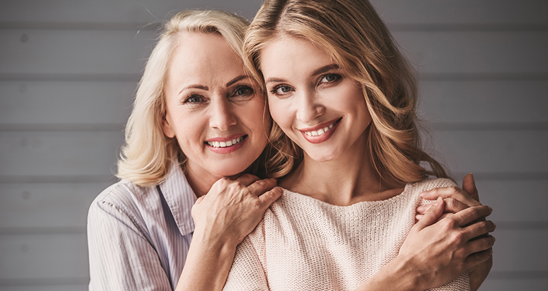 Madre adulta abrazando a su hija tras recibir las felicitaciones del Día de la Madre 