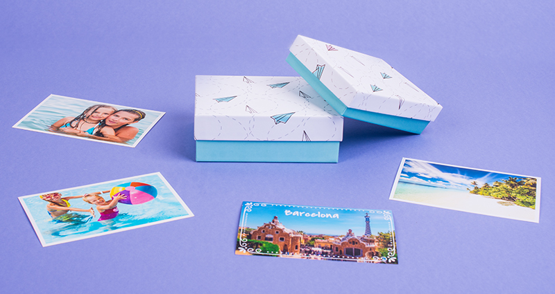 Boxes for photo prints with origami theme in two sizes, surrounded by spread photo prints – purple background.