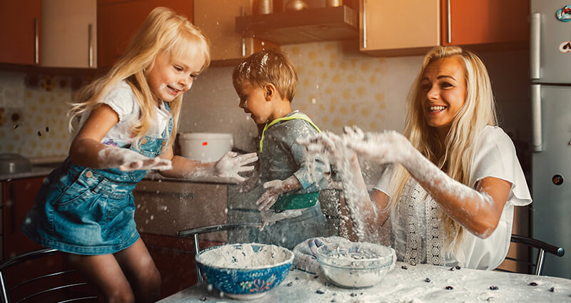 Children cooking with her mum in the kitchen.