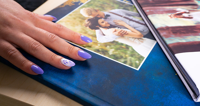 Close-up on female’s hand touching the matte navy blue Starbook cover. 