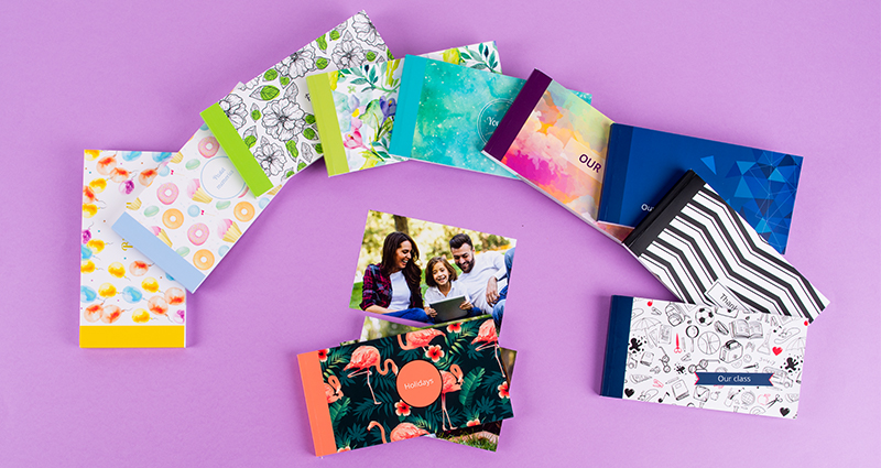Sammlung der 10 neuen Sharebooks in Form eines Hufeisens, in der Mitte das Flamingo-Sharebook und lose arrangierte Fotos.