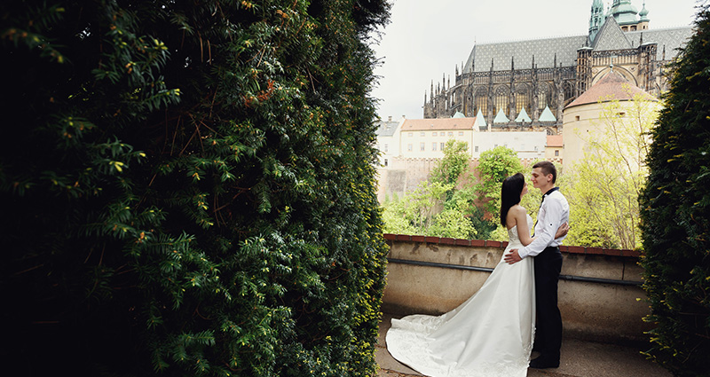 Une photo de Jeunes Mariés à Prague, au fond un château.