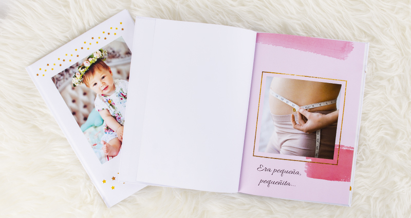 Fotolibro de bebé con fotos de la barriga de una mujer embarazada en la primera página.